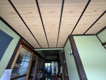 安芸高田市の住宅室内、天井の木目パネルに広がる雨染み。太陽光パネル下の雨漏りが2階天井に到達