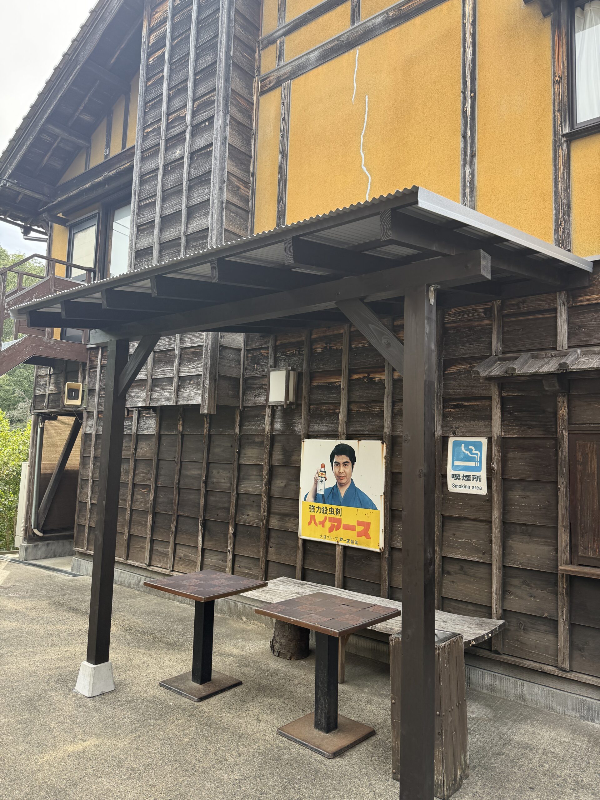 飲食店の喫煙所に完成した雨よけ屋根。木の柱と透明ポリカ屋根で開放的な仕上がり